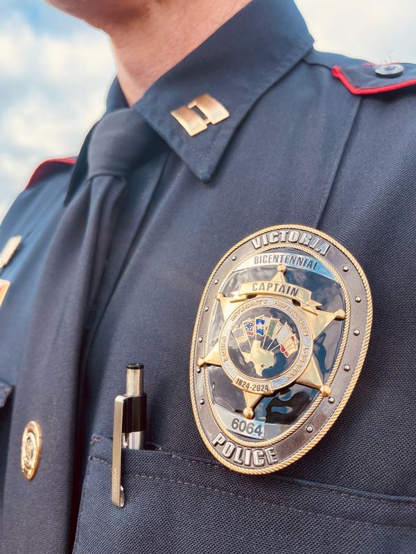 A police badge with an image of the City seal reads Victoria Police. Bicentennial. Captain.