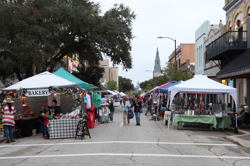 Residents browse tent booths on Main Street in downtown Victoria. Some booths have Christmas decor