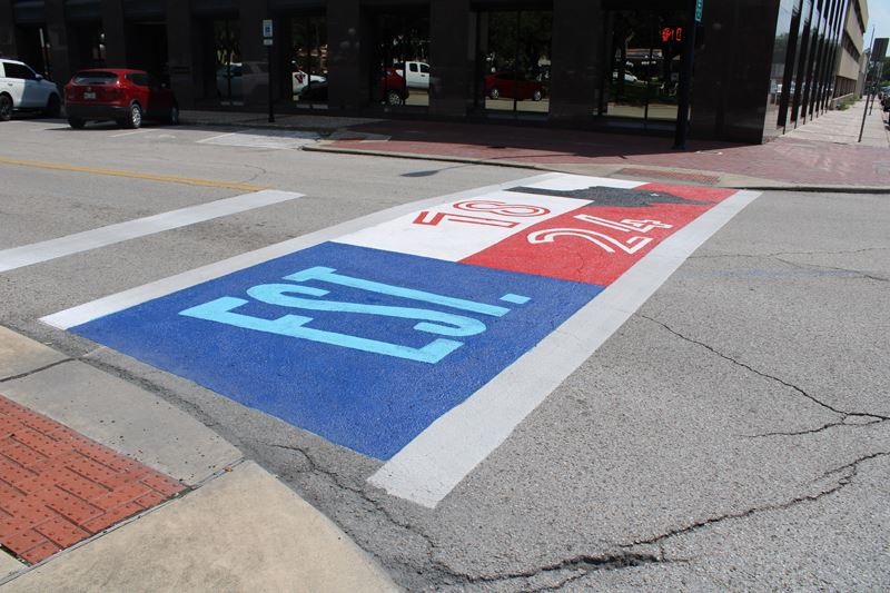 Crosswalk with art of Texas flag labeled Established 1824