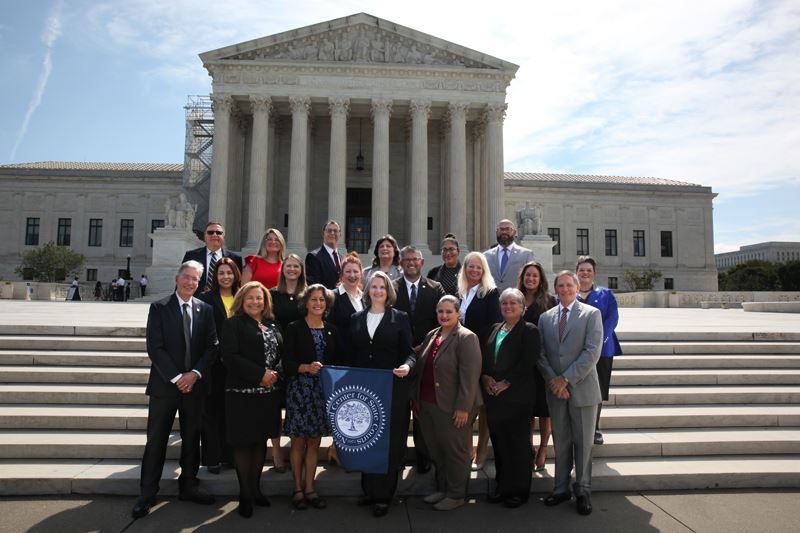 Large group photo in front of the Supreme Court building